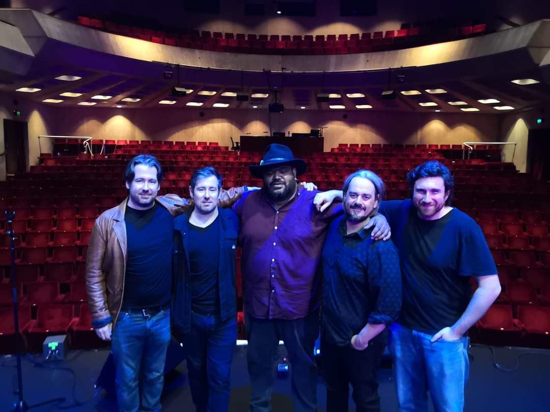 The band on stage in front of an empty theatre before a show